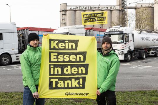 Greenpeace Aktivist:innen protestieren mgegen die Verwendung von Getreide und Pflanzenölen in Kraftstoffen vor einer Ölmühle. Die Umweltaktivist:innen fordern: "Kein Essen in den Tanks!"