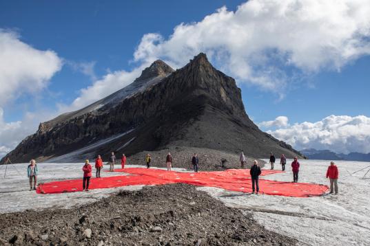 Die KlimaSeniorinnen bei einer Protestaktion vor einem Gletscher