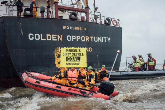 Greenpeace-Aktivisten schreiben in großen Lettern "End Coal" an die Bordwand des Kohlefrachters "Golden Opportunity"