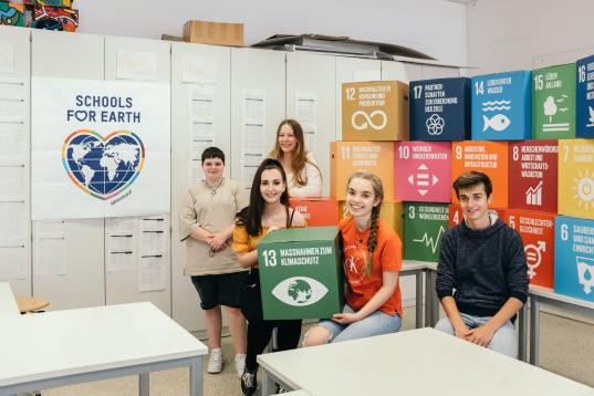 Schüler:innen der Ernst-Reuter-Schule in ihrem Klassenzimmer mit Schools for Earth Poster im Hintergrund