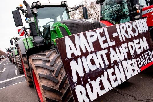 Traktor mit Schild auf der Straße: "Ampel-Irrsinn nicht auf dem Rücken der Bauern".