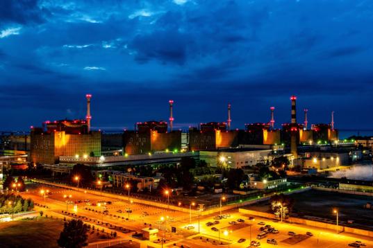 Kraftwerksblöcke und das Gelände des Atomkraftwerks Saporischschja sind nachts beleuchtet