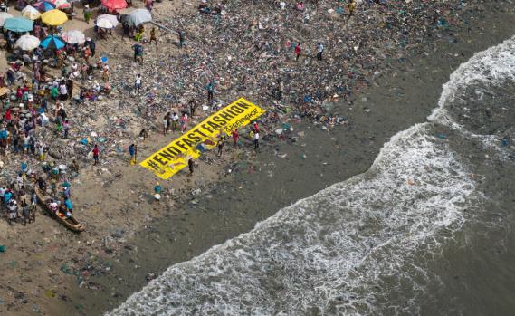 Fast Fashion und Abfallkolonialismus – ein Greenpeace-Banner am Strand in Ghana mit der Aufschrift "END FAST FASHION"