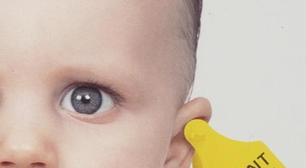 Baby mit Patentclip im Ohr. Symbol für Patente auf Leben.