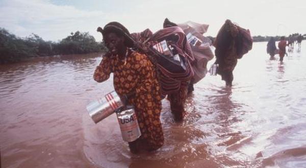 Überschwemmung in Somalia. Flüchtlinge tragen ihre Habseligkeiten durchs Wasser.  