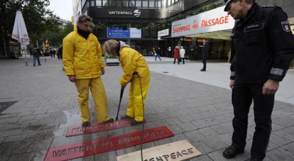 Greenpeace-Aktivistinnen haben mit Hilfe eines Hochdruckreinigers: "Klima schützen - Vattenfall kündigen" auf die Straße vor dem Vattenfall-Kundenzentrum in Hamburg geschrieben.