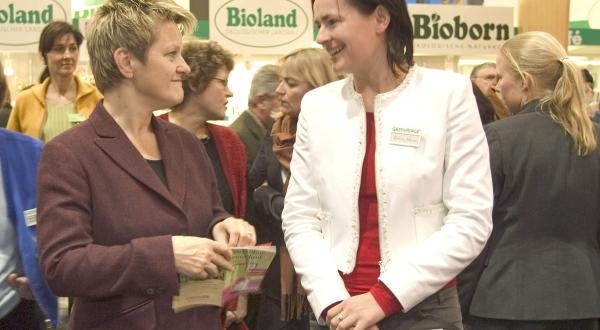 Corinna Hölzel (rechts) überreicht Renate Künast, Landwirtschaftsministerin, den aktualisierten Einkaufsratgeber "Essen ohne Gentechnik"
