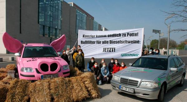 Greenpeace-Aktivist:innen mit einem "Klimaschwein" und einem sauberen Mercedes mit Filter fordern von Bundeskanzler Schröder, gegen Dieselabgase und Feinstaubpartikel vorzugehen.