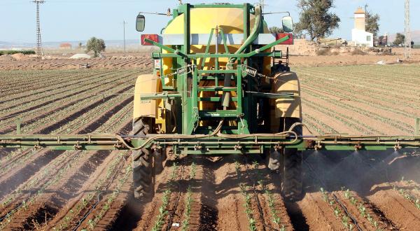 Ein Traktor versprüht auf einem Feld in Spanien Pestizide.