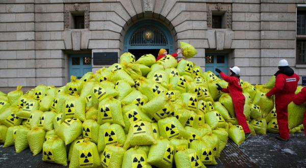 Aktion gegen Atommüll mit einem Berg von Müllsäcken mit dem Strahlenwarnzeichen vorm Wirtschaftsministerium in Den Haag
