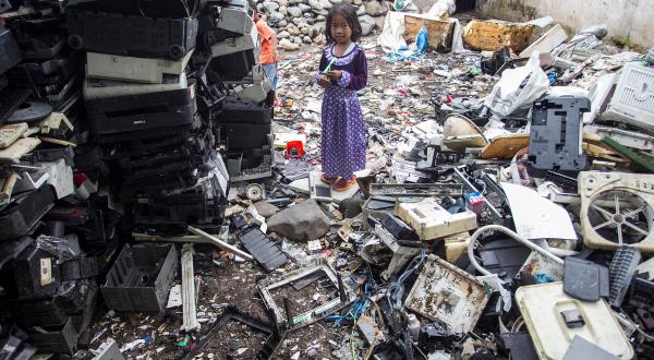 Little Girl plays at Dumpsite for Electronic Waste in Jombang