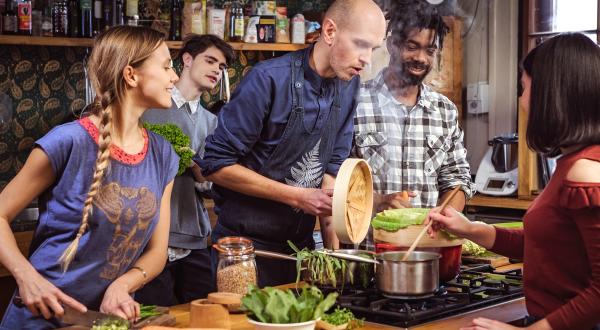 Junge Erwachsene bereiten gemeinsam mit dem Meister der veganen Küche Domen Kavcic vegetarische Gerichte zu.