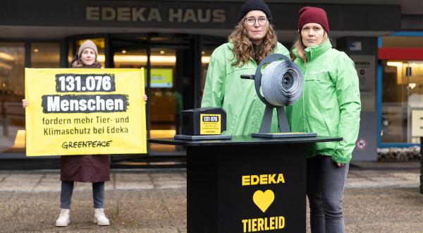 Aktive vor Edeka mit Banner "131 076 Menschen fordern mehr Tier- und Klimaschutz bei Edeka" und überdimensionierter Kassenbon-Rolle. 