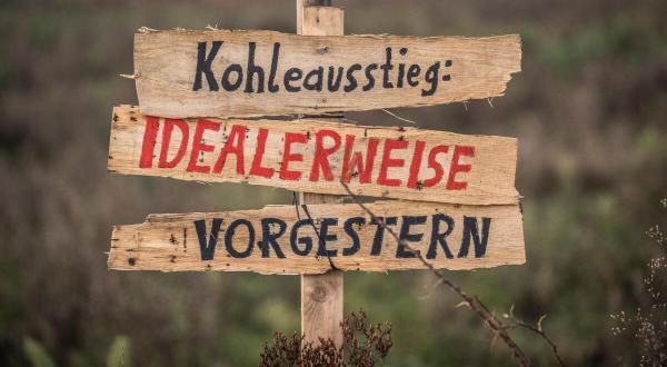 Schilder fordern schnellen Kohleausstieg in Lützerath