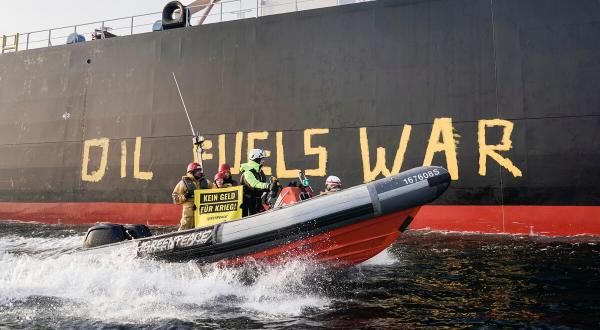 Greenpeace-Aktivist:innen demonstrieren im Fehmarnbelt mit einem Schlauchboot gegen Ölimporte aus Russland, die Putins Krieg in der Ukraine mitfinanzieren. Die Aktivist:innen malen "OIL IS WAR" auf die Seite des Tankers "Stamos", der Rohöl aus dem russischen Ostseehafen Ust-Luga nach Rotterdam liefert.