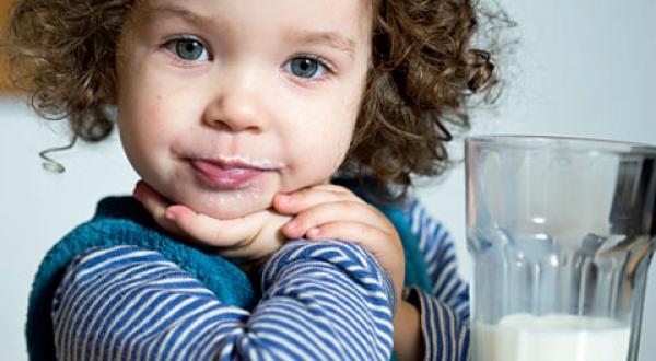Mädchen, 2 Jahre, trinkt Milch aus einem Glas. 
