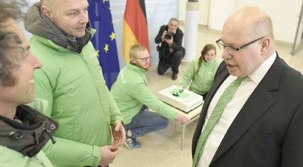 Greenpeace-Aktivisten überreichen Bundeswirtschaftsminister Peter Altmaier eine Torte mit Kohlekraftwerken aus Marzipan.