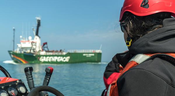 Arctic Sunrise im Sylter Außenriff, Aktivist auf Schlauchboot im Vordergrund