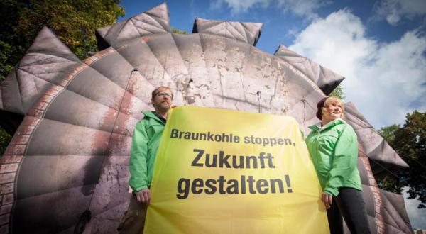 Greenpeace Aktivisten demonstrieren bei den Koalitionsverhandlungen zwischen SPD und Die Linke in Brandenburg für den Kohleausstieg. Vor dem Tagungshotel fordern sie mit einem aufblasbaren Braunkohle-Baggerrad und einem Banner: "Braunkohle stoppen, Zukunf