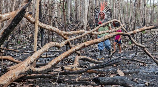 Mitglieder des  Huni Kuin-Stammes laufen durch verbrannten Amazonas-Regenwald