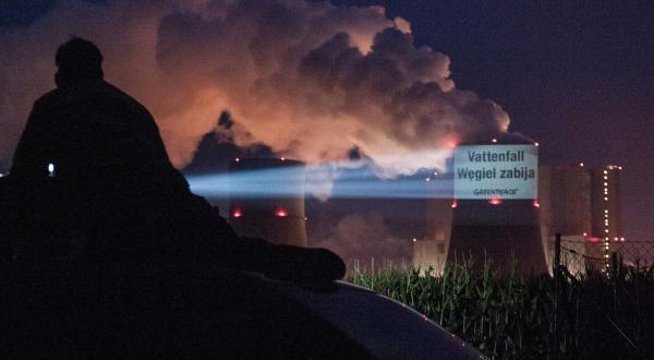 17. September 2013: Greenpeace-Aktivisten projizieren in mehreren Sprachen - hier auf Polnisch - Slogans auf das Kohlekraftwerk Schwarze Pumpe. Auf Deutsch: „Vattenfalls Kohle tötet“ 
