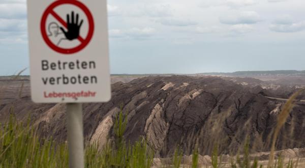 "Betreten verboten" Schild vor einem Braunkohletagebau
