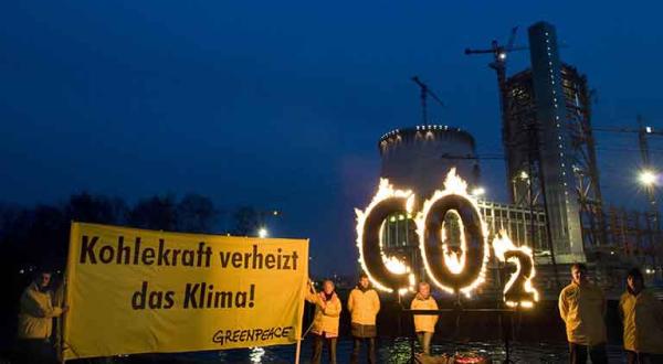 Greenpeace Aktivisten protestieren mit einem brennenden CO2 Zeichen vor der Baustelle eines neuen E.ON-Kohlekraftwerks in Datteln, Dezember 2008