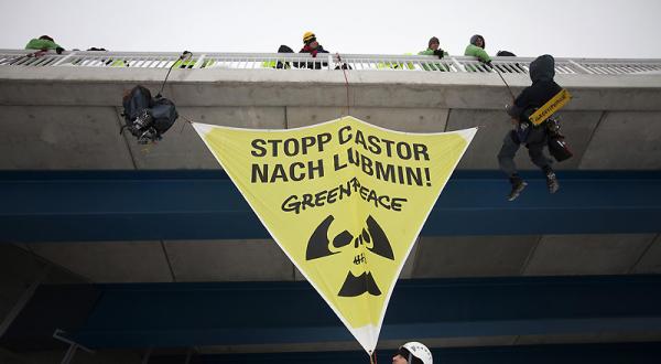 Greenpeace-Kletterer befestigen ein Banner über den Bahngleisen zwischen Greifswald und Lubmin 12/16/2010