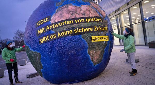 Greenpeace-Aktive mit Weltkugel vor CDU-Parteitag