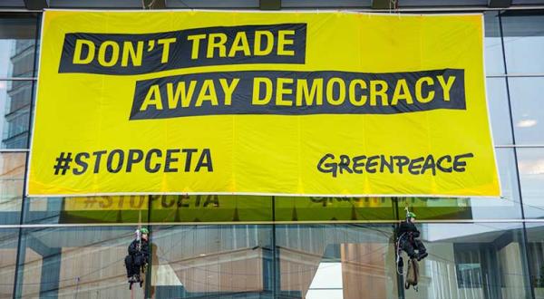 Greenpeace-Aktivisten hängen ein 12 mal 6 Meter großes Banner mit der Aufschrift “Don’t trade away our democracy" an das EU-Ratsgebäude in Luxembourg