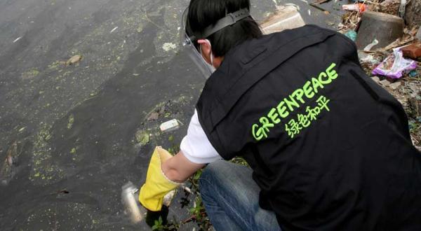 Greenpeace-Aktivist nimmt Wasserprobe in China im Mai 2012