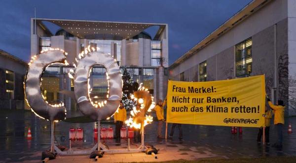 Aktivisten demonstrieren mit brennendem CO2 Zeichen für mehr Klimaschutz vor dem Bundeskanzleramt, Dezember 2011