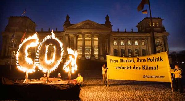 Greenpeace Aktivisten demonstrieren mit einem brennenden CO2 Zeichen vor dem Reichstag gegen die Klimapolitik der Bundeskanzlerin, Dezember 2008