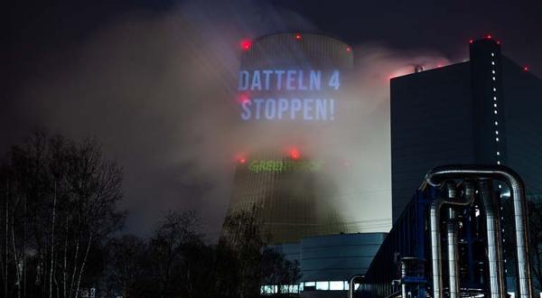 Aktivistinnen und Aktivisten projizieren verschiedene Bilder auf den Kühlturm des Kohlekraftwerks Datteln 4