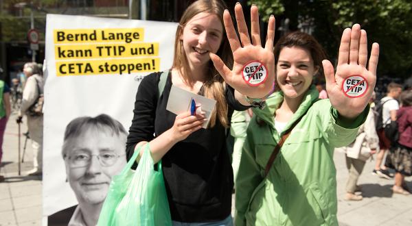 Greenpeace-Ehrenamtliche in Hannover vor dem Plakat des EU-Abgeordneten Bernd Lange. Sie fordern: TTIP und Ceta stoppen!