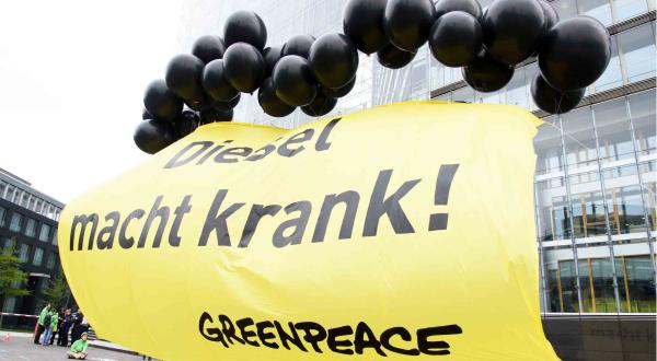 Greenpeace-Aktion: Schwarze Luftballons halten ein Banner, auf dem steht "Diesel macht krank".