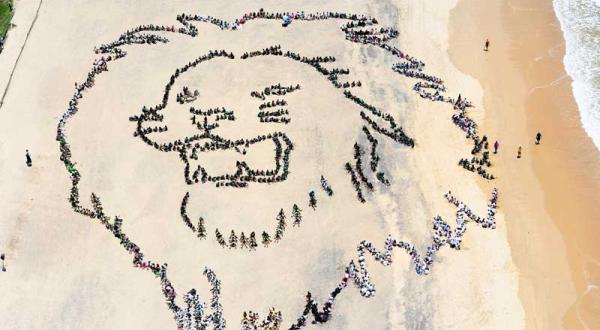 Am Strand von Durban formatieren Jugendliche sich gemeinsam zu einem Löwenhaupt, Dezember 2011