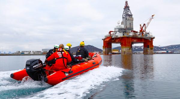 Greenpeace-Aktivisten fahren im Schlauchboot auf Ölplattform zu