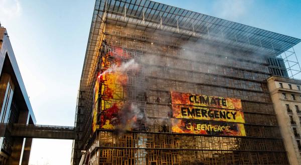 Greenpeace-Protest mit Feuerbannern an EU-Regierungsgebäude