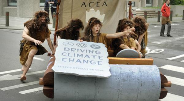 Greenpeace-Aktivisten fahren mit einem Steinzeitauto vom ACEA Hauptgebäude zum Europäischen Parlament.