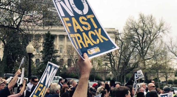 Demonstrant hält auf einer Anti-TPP-Demonstration ein Plakat mir der Aufschrift "No fast track" hoch.