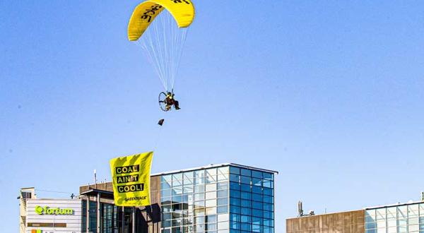 Gleitschirm mit Banner "Coal ain't cool" über dem Fortum-Hauptsitz in Espoo, Finnland