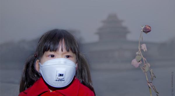 Kind mit Atemschutzmaske in Peking, China