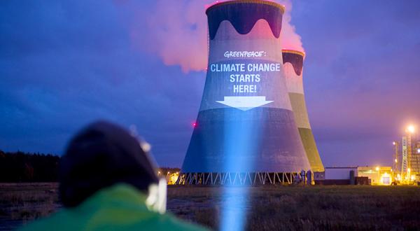 Greenpeace-Aktivist bei Projektion auf Kohlekraftwerk in Polen