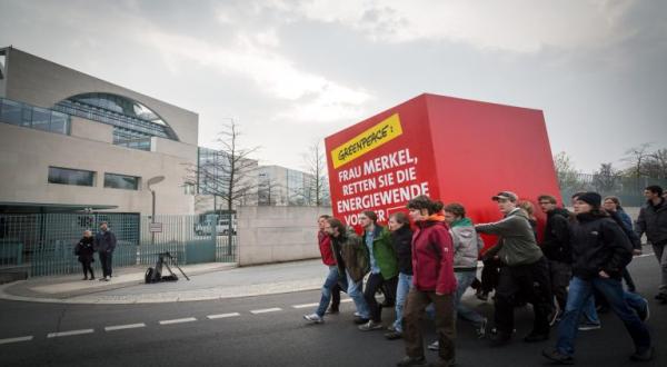 Greenpeace Aktivisten protestieren mit einem überdimensional großen Würfel vor dem Bundeskanzleramt, 01.04.2014