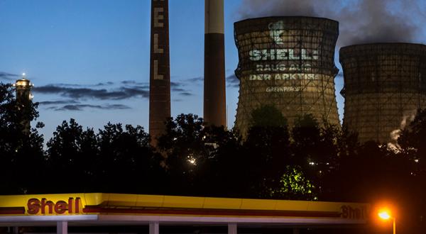 Greenpeace-Projektion hinter Shell-Tankstelle