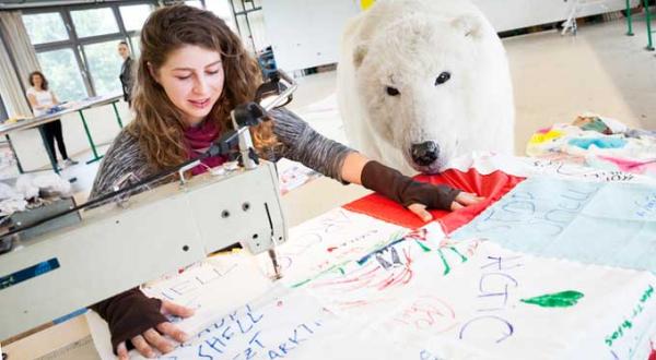 Greenpeace-Mitarbeiterin näht am Riesen-Feudel für Shell, im Hintergrund bereits vernähte Lappen und Paula-Bär.