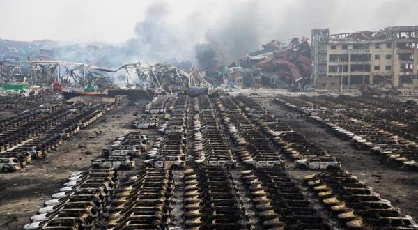 Ausgebrannte Autos, dahinter Häuser, die die Explosionen ebenfalls zerstörten.