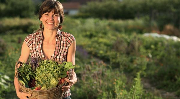 Frau mit Gemüsekorb auf Feld