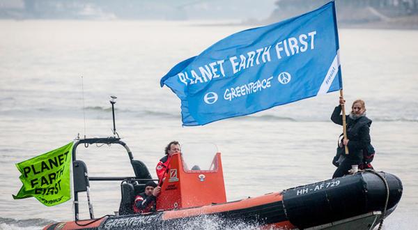 Schlauchbootaktivisten auf dem Rhein demonstrieren mit Fahne "Planet Earth First"